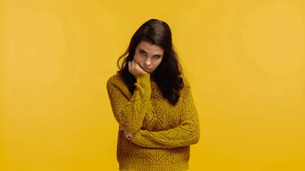 Mujer morena disgustada en suéter mirando a la cámara aislada en amarillo - foto de stock