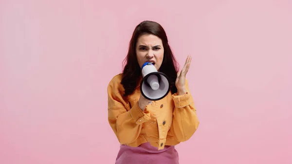 Раздраженная женщина делает объявление в мегафоне изолированы на розовый — стоковое фото