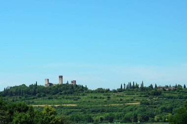 Medieval Italian castle built in a valley.Towers of an ancient castle among the vegetation of the countryside.      