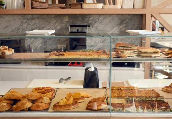 Elegant counter of a sandwich shop with Italian dishes on display.Calzone, pretzels, hot dogs, quiche and sandwiches. Italian style.