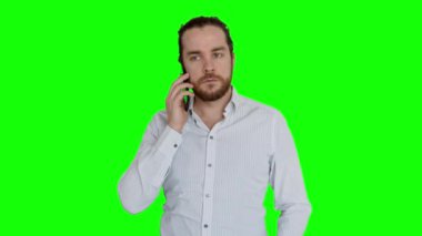 Beyaz gömlek giyen genç bir ofis görevlisine telefon geliyor. Sakallı ve çörekli adam ofiste akıllı telefonunu kullanıyor. Yeşil Ekran.