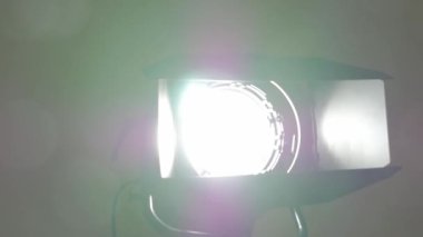 Bir sinema spotunun yakın çekimi. Ahırın kapıları ve yumuşak, sıcak, beyaz bir ışıkla spot ışıklarının önünde hareket halinde çekim yapmak. Film stüdyosunda ışıklandırma. Tiyatro yapımı ve mercek patlaması.