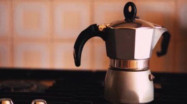 Bir adamın eli sobayı kapatır ve bir moka içer. Bir İtalyan evinde kahve zamanı. Kahve içenler ve kahve içenler..