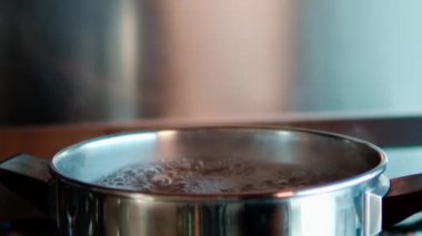 Put the salt in boiling water.Preparation of pasta, Italian tradition. Close up and zoom in.