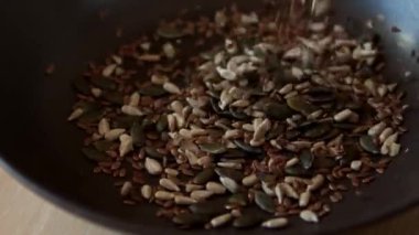 Close up of various seeds poured into a dish.