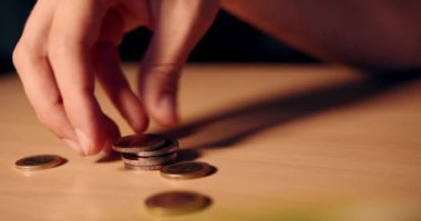 Hand stacks some European coins. Man's hand collects and plays with coins of 50 cents, one and two euros. Wealth, investment and money. Slow motion 4k video.