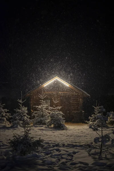 Magical winter night in the mountains. Blizzard scene on the wooden cabin on the back