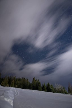 Kalp şeklindeki gökyüzü kış gecesinde dağlardaki köyde