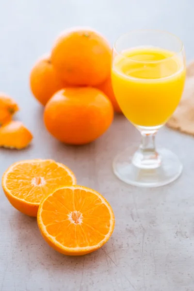 Spremendo un bicchiere di succo d'arancia fresco Immagine Stock