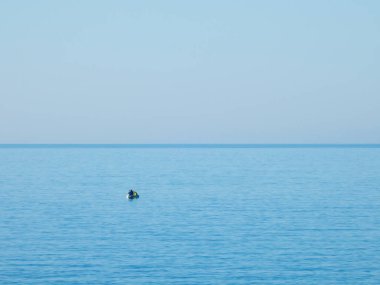 Akdeniz 'de şişme bir teknede üç balıkçı.