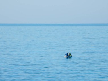 Akdeniz 'de bir teknede üç adam balık tutuyor.