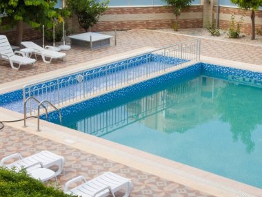 ALanya, Turkey - 20 Haziran 2022. Kimyasal temizlikten önce, yüzme havuzunun yakınındaki dinlenme yeri suyla doluyor.