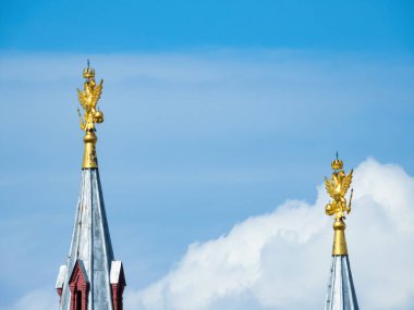 Moskova, Rusya - 22 Mayıs 2019: Tarihi Müze 'nin iki ana kulesinin tepesindeki hava durumu horozları, yaldızlı çift başlı kartallar şeklinde. Geniş yüzlü rüzgara doğru dön.