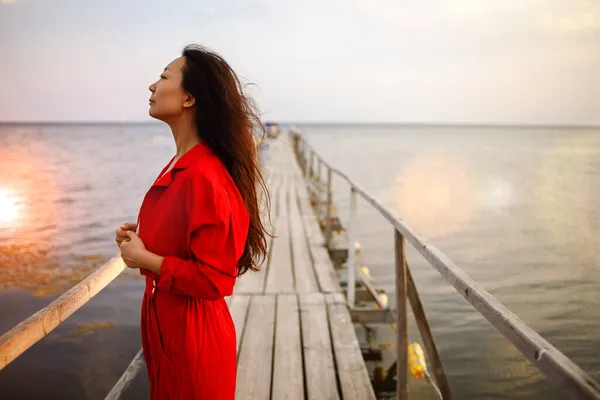 Güzel Asyalı Kadın Kırmızı Takım Elbiseli Eski Ahşap Iskelede Yürüyor — Stok fotoğraf