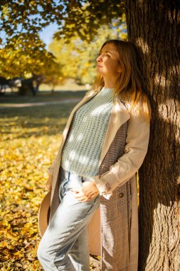 Gün batımında genç ve güzel bir bayan. Sarı saçlı ve kahverengi gözlü. Ilık sonbahar. Ilık bahar, güneş ışınları arkadan.