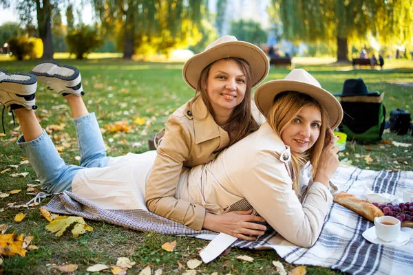 Krásní Přátelé Tráví Čas Piknikové Přikrývce Trávě Dvě Mladé Bezstarostné — Stock fotografie