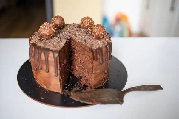초콜릿으로 장식된 초콜릿 케이크는 화이트 테이블에서 케이크가 팝업되고 캔디가 만들어 — 스톡 사진