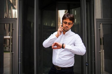 İşletme işletmeciliğinin idari müdürü sabah erken saatlerde telefonda yöneticilerle konuşurken şehrin finans caddelerinde bir yandan da konferans için koşturuyor.