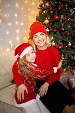 Anne ve kızını seven, Noel ağacının yanında sarılan, harika görünen..