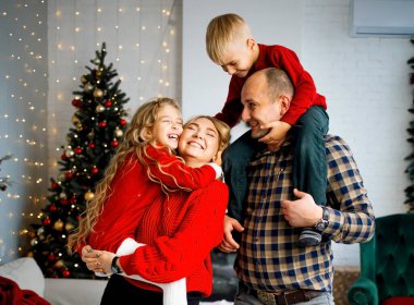 Çocuklu mutlu genç bir aile Noel 'i kutlarken eğleniyor. Evde Noel zamanı.