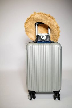 Pastel mavi arka planda şapka ve kamera olan bavul. seyahat konsepti. Kopyalama alanı olan en küçük biçim.