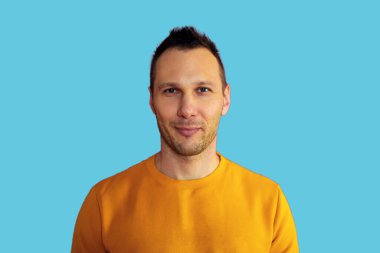 Portrait of charming young man feel content emotions wear yellow shirt isolated over blue color background