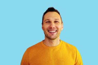 Portrait of charming young man feel content emotions wear yellow shirt isolated over blue color background