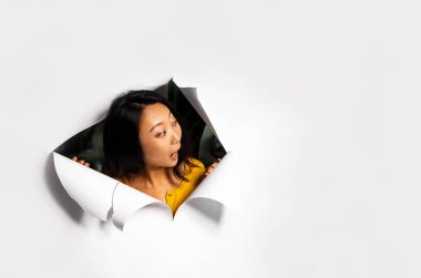 Boş fotokopi alanındaki beyaz stüdyo arka planında izole edilmiş gülümseyen Asyalı kadın portresi. Mutlu kadın gösterisi iyi bir tanıtım anlaşması ya da indirimi. Ticaret konsepti. Yırtık kağıt.