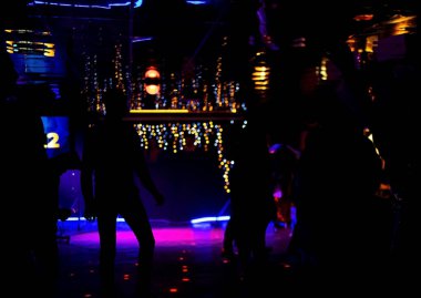 Bir yeraltı kulübünde dans eden insanlar. Renkli ışıkların altında dans eden insanlarla dans pisti.