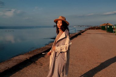 Güzel genç Asyalı kadın kışın iskelede duruyor.