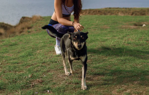 Dağlarda köpek oynatan bir kız. Köpeğiyle deniz kenarındaki bir uçurumda oturan bir kadın..
