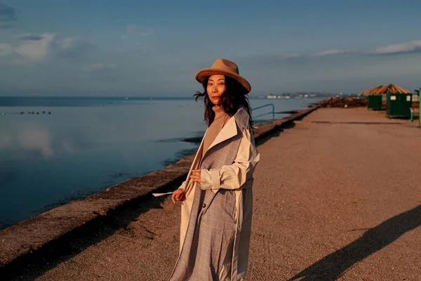 Güzel genç Asyalı kadın kışın iskelede duruyor.