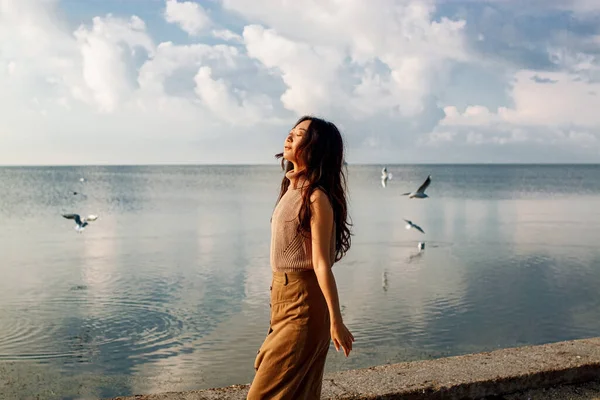 Güzel genç Asyalı kadın kışın iskelede duruyor.