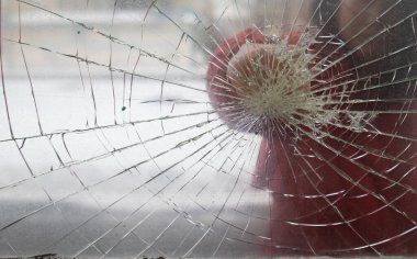 Fist demolishing windowpane. Fist punching thru a glass window