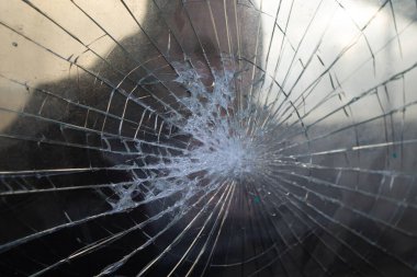 Fist demolishing windowpane. Fist punching thru a glass window