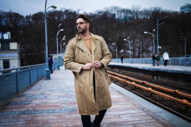 Yakışıklı sakallı adam metro tren bekliyor.