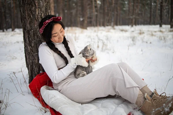 Ázsiai Lány Egy Nyulat Tart Karjaiban Egy Havas Erdőben Barátság — Stock Fotó