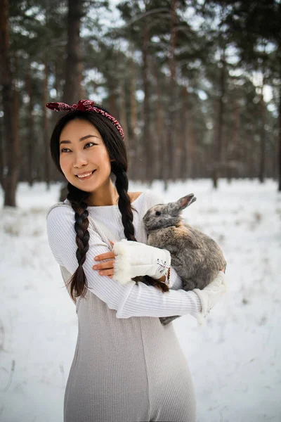 Азиатская Девушка Держит Кролика Руках Заснеженном Лесу Дружба Пасхальным Кроликом — стоковое фото