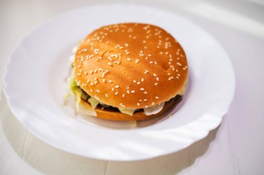 beyaz bir arka plan üzerinde bir tabakta marul ile hamburger, üst görünümü