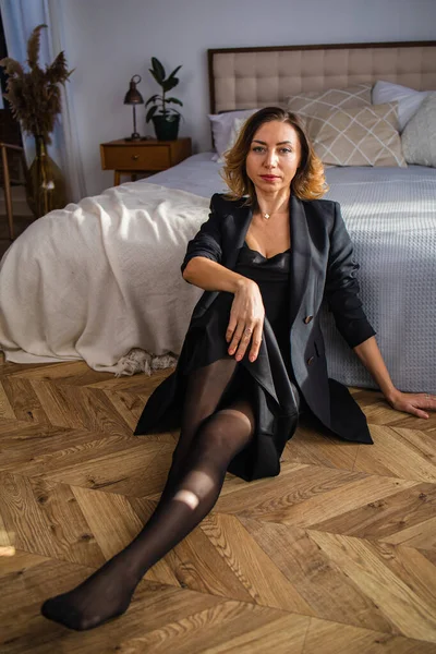 Evdeki rahat bir oturma odasında ciddi ve düşünceli bir kadının portresi..