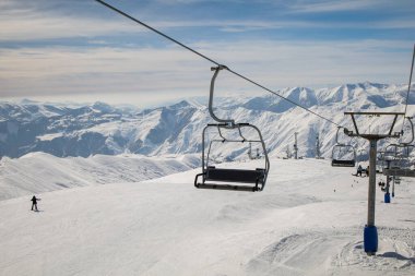 Güneşli bir akşamda Alp Dağları 'nda kayak asansörü boş. İnsanların kayak ve snowboard yapmaktan hoşlandığı teleferik kablosu..