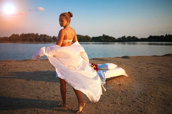 年轻性感的金发女子 穿着花边女士内衣 夕阳西下 湖中缀着一束红玫瑰 — 图库照片