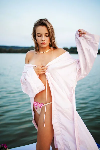 日落时 一个穿着粉色浴衣的漂亮金发姑娘站在湖边 童话故事 — 图库照片