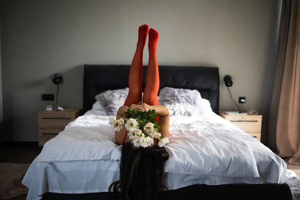 3月8日 性感的小女孩躺在白床上 开着鲜花 一束新鲜的玫瑰 — 图库照片