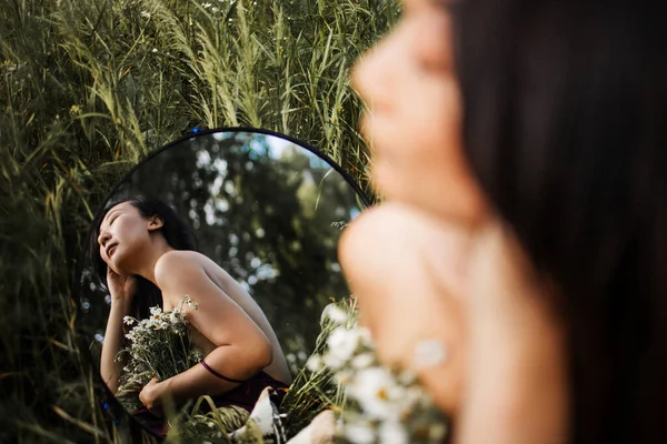 美丽的亚洲年轻女子坐在有镜子的甘菊田里 复制空间 沉思的梦想家选择性重点 — 图库照片