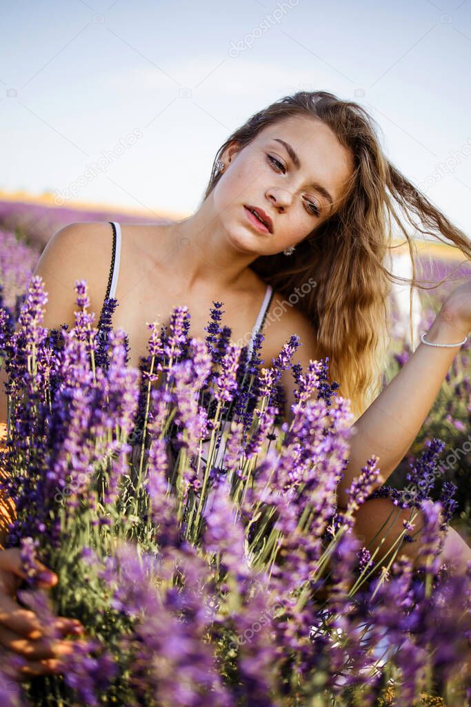 Beautiful girl on the lavender field. Beautiful blonde woman in the lavender field on sunset. Soft focus