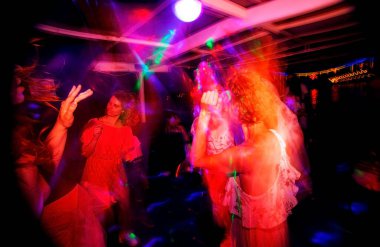 Konserdeki kalabalık, renkli sahne ışıkları içinde tezahürat yapan bir kalabalık. Mutlu arkadaşlar tatil ışıkları olan bir kulüpte dans ediyorlar..