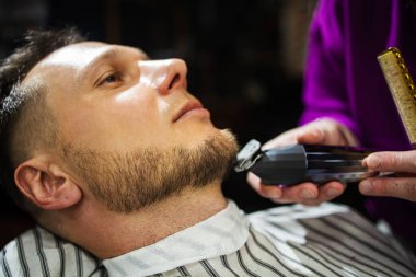 Berber dükkanı tıraş eden hippi bir adam..