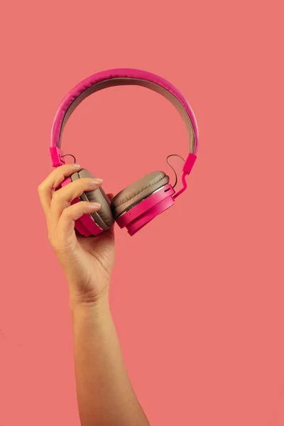 Hand Holding Pink Headphones Isolated Pink Background — стоковое фото