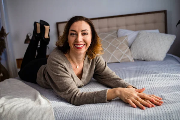 Başarılı orta yaşlı kadın evde gülümsüyor. Kızıl saçlı, orta yaşlı, güzel bir kadın.